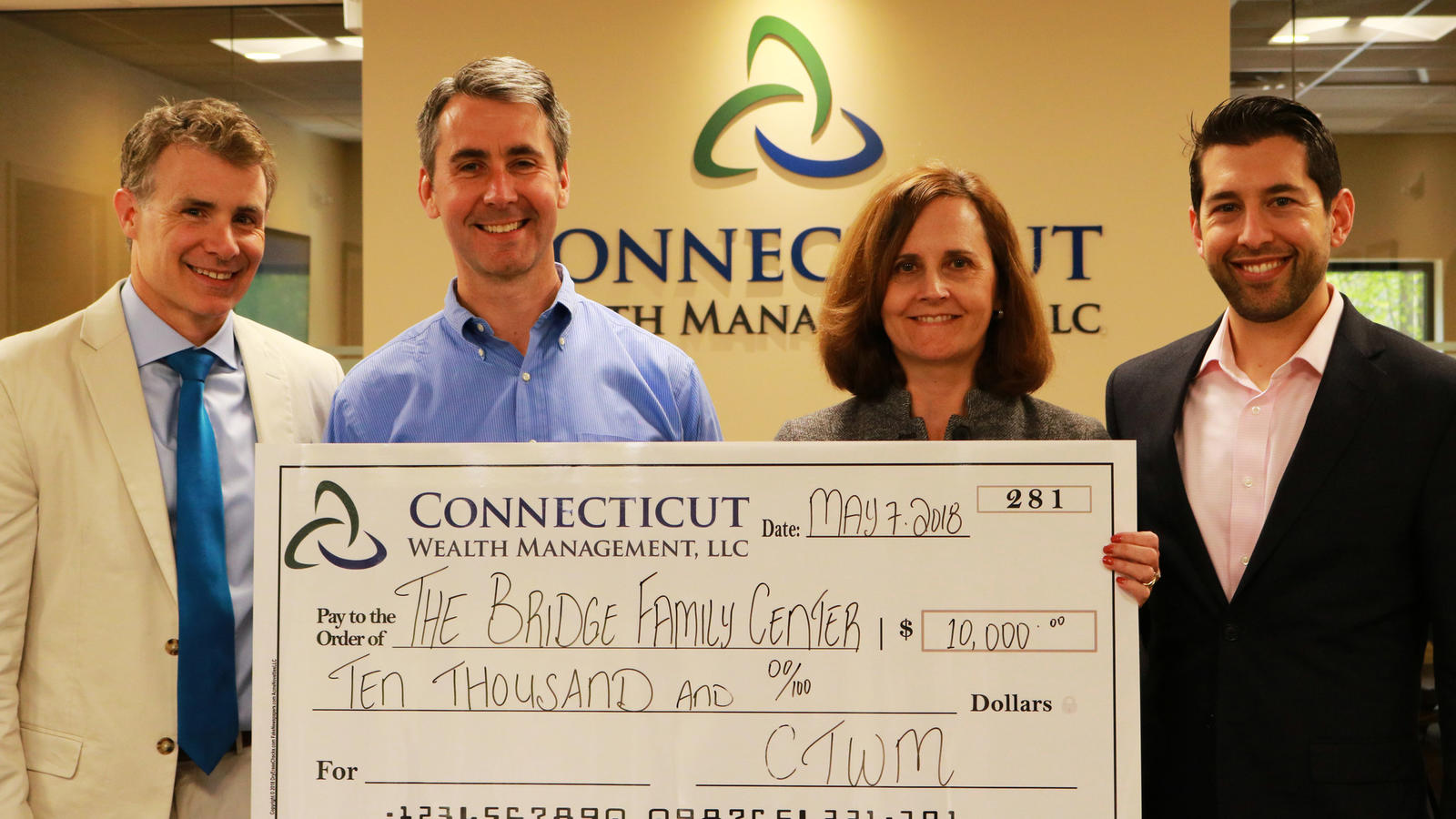 Members of Connecticut Wealth Management with a $10,000 check donation for The Bridge Family Center